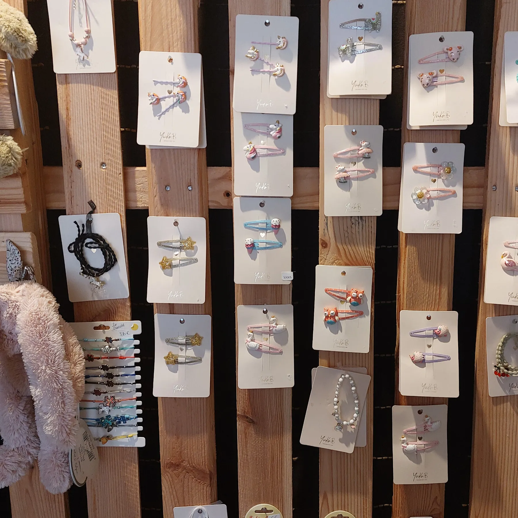 Un panneau de bois couvert de barrettes et de bijoux pour enfants.