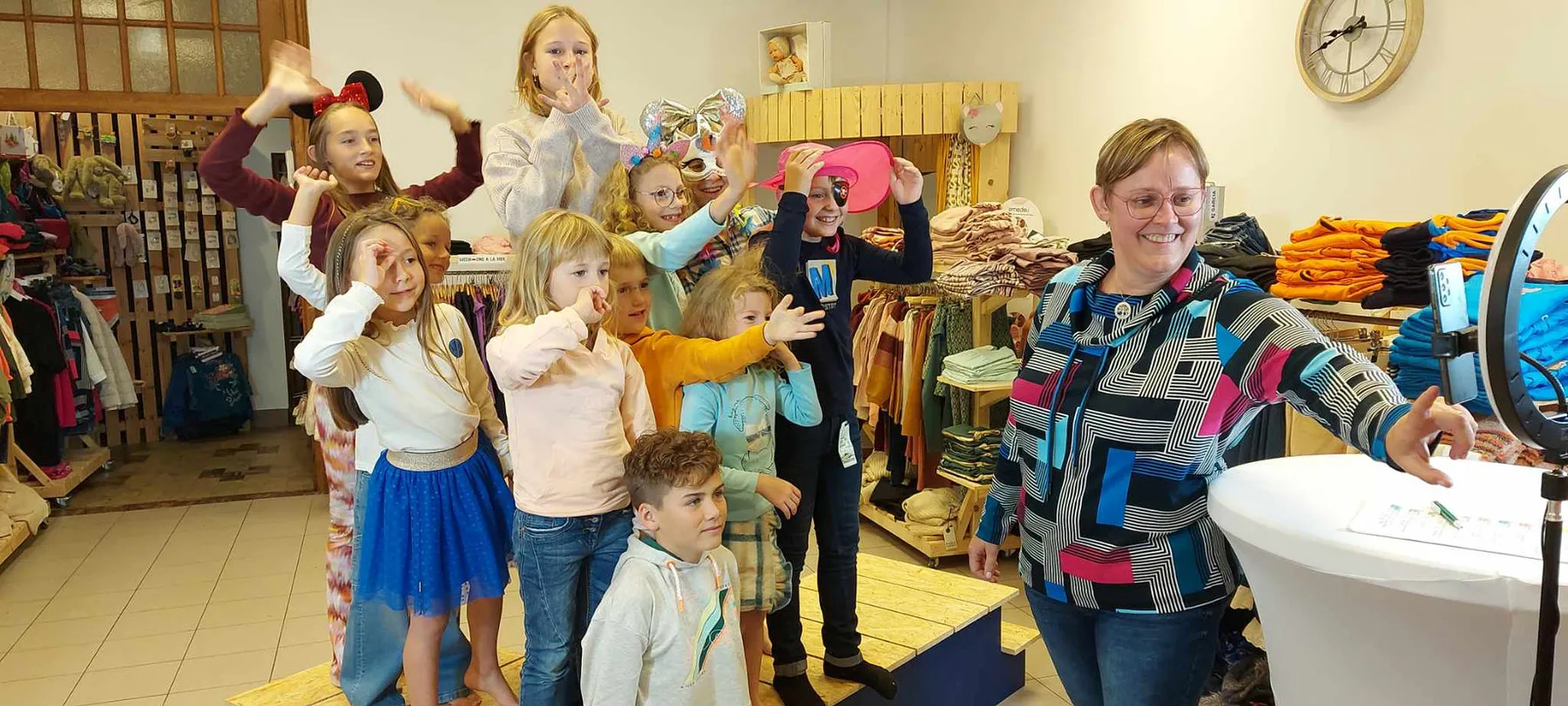Un groupe d'enfants pose en riant au milieu de la boutique pendant un essayage.